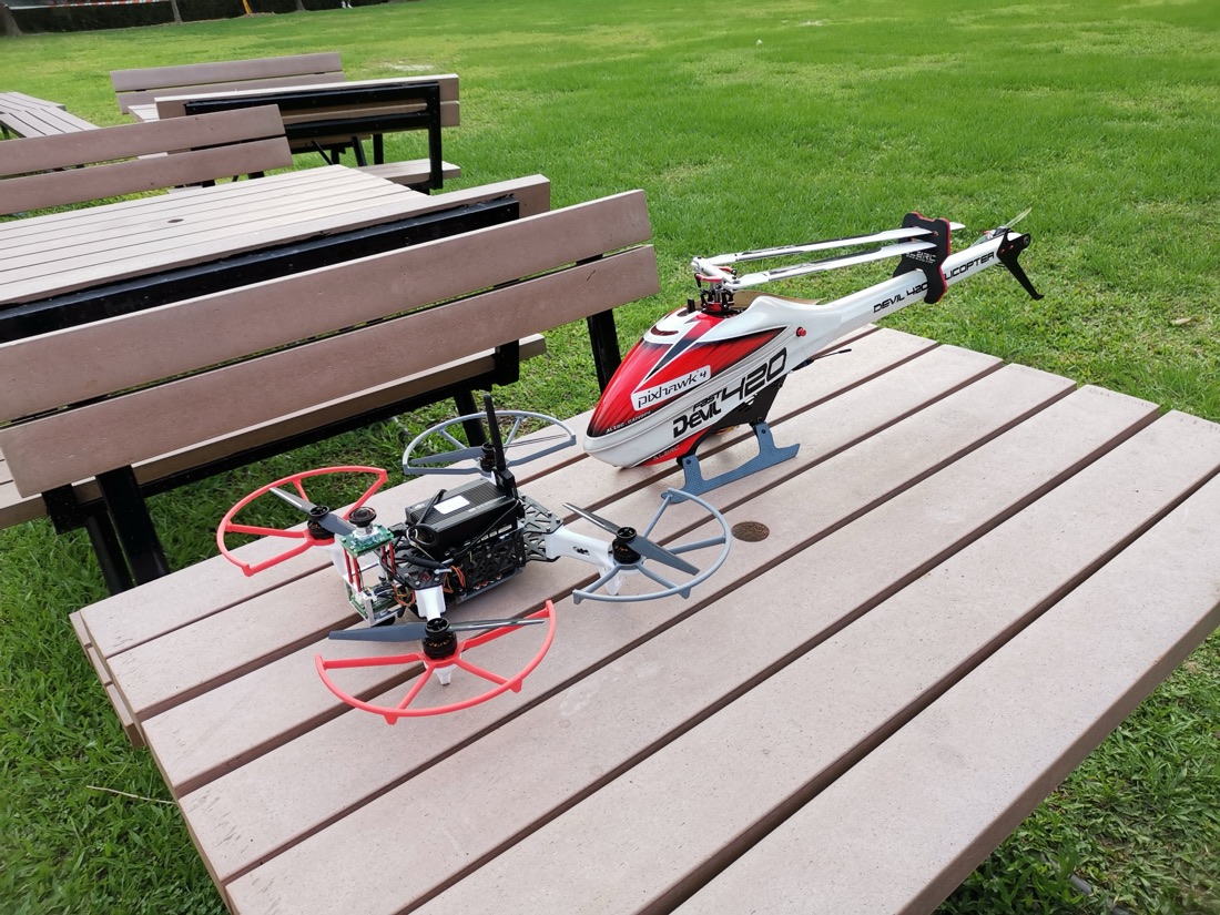 An RC helicopter and a quadrotor on a picnic table